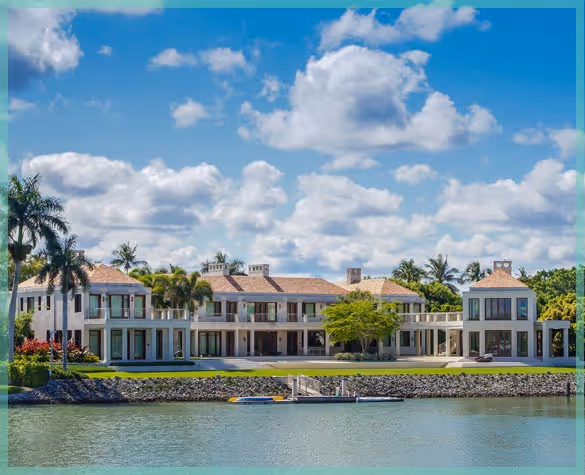 Luxurious waterfront estate with a private dock and tropical landscaping, representing high-end residential relocation services