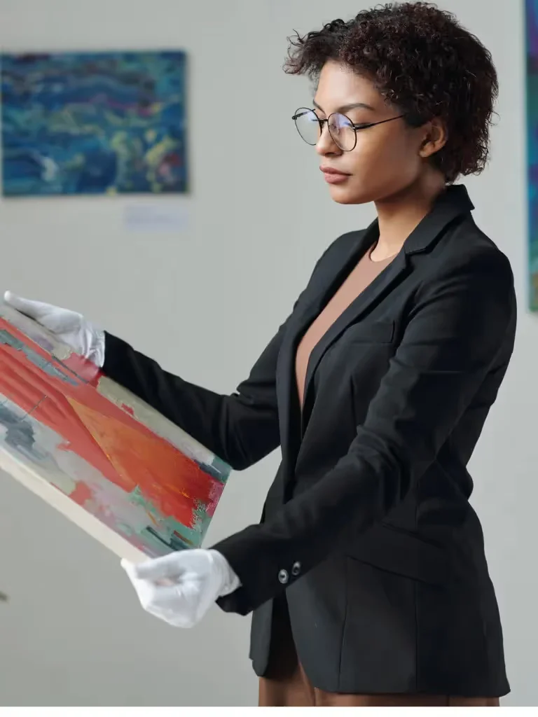 Gallery professional in white gloves handling an abstract canvas painting