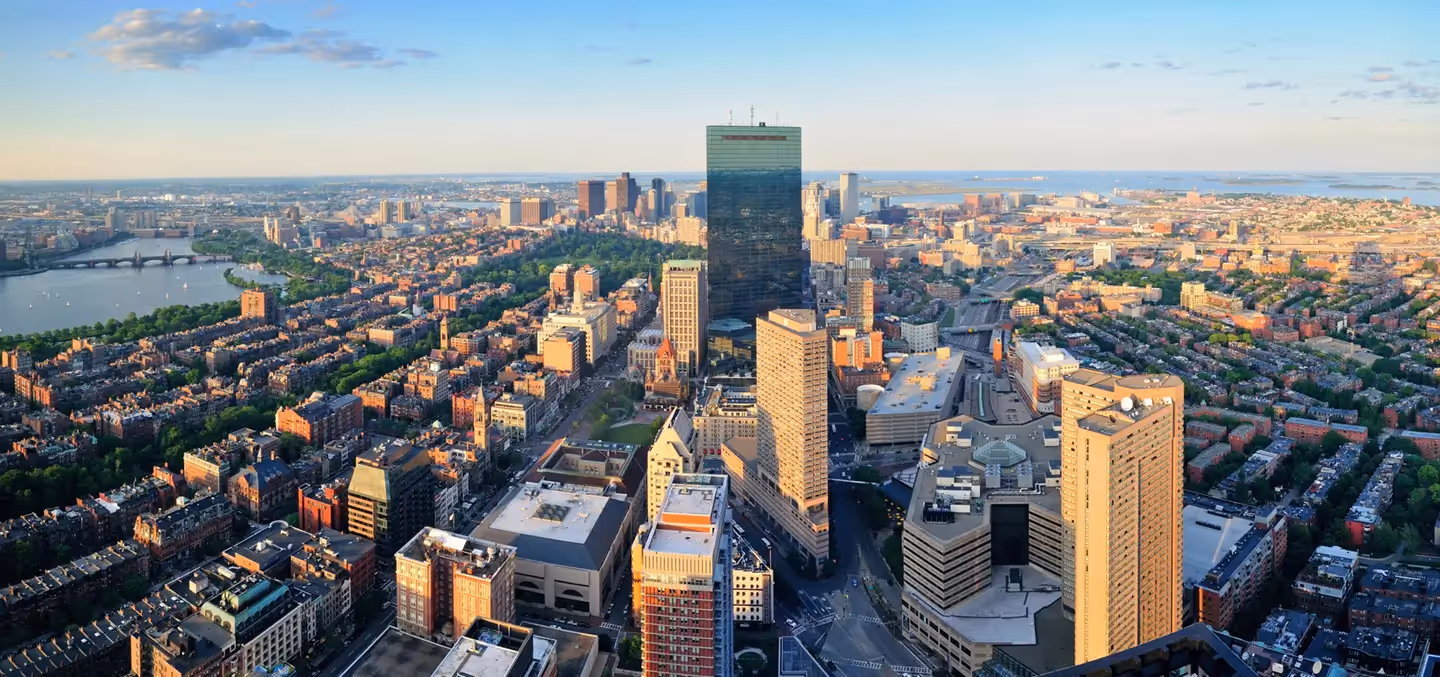 Aerial view of the Boston skyline featuring the Prudential Tower and Back Bay at sunset.