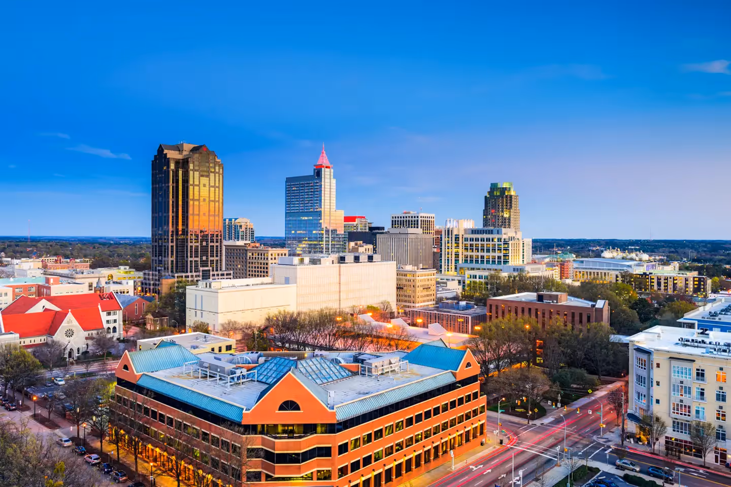Wide-angle aerial view of the Raleigh skyline and downtown buildings at dusk in North Carolina