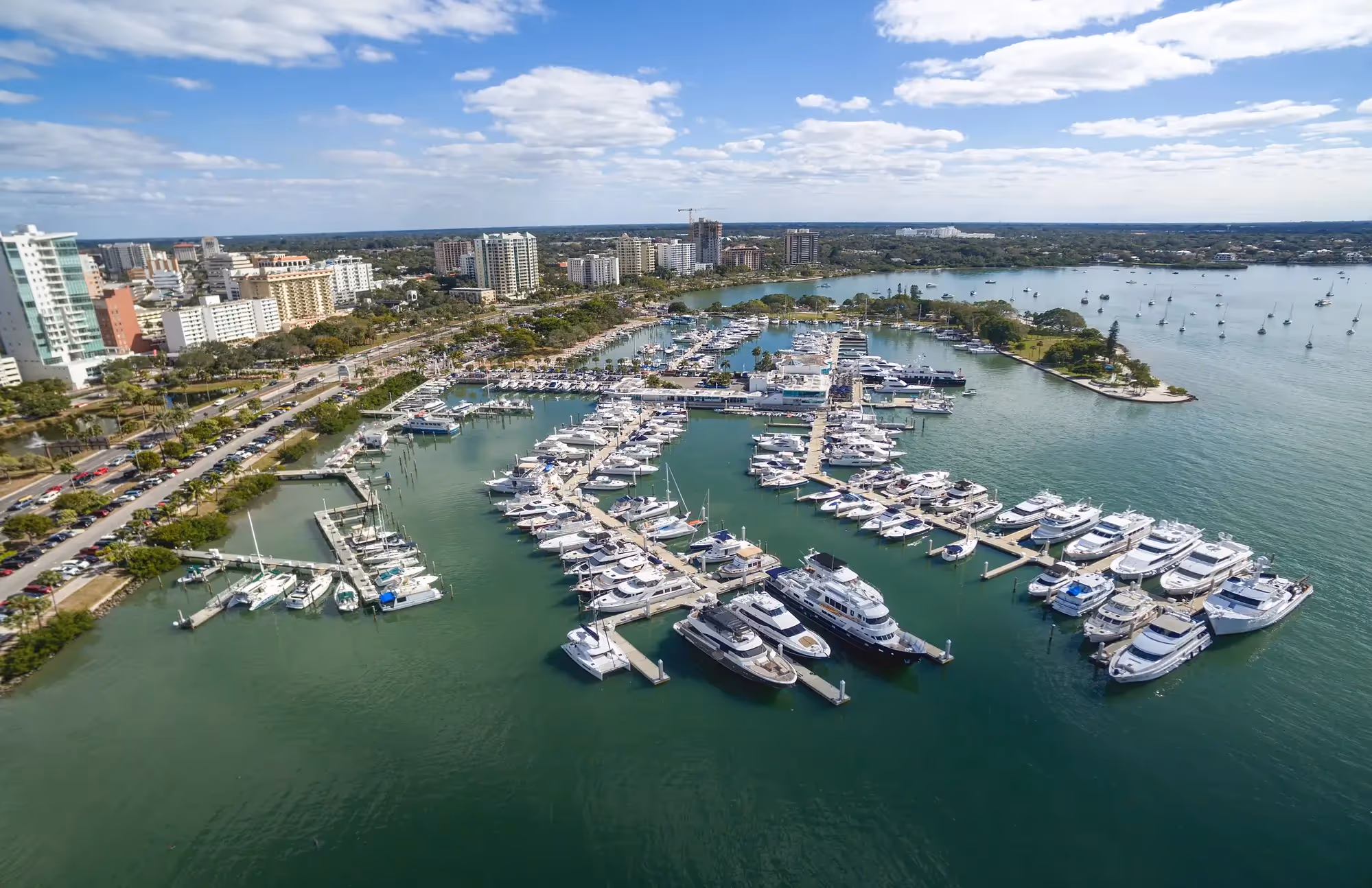 Aerial view of the Sarasota skyline and bayfront at sunset with luxury condominiums and palm trees