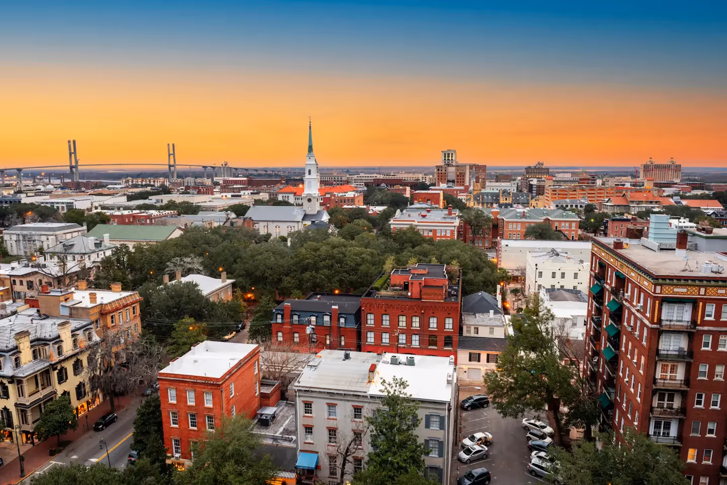 Aerial view of the Savannah riverfront and historic district at twilight with the Talmadge Memorial Bridge