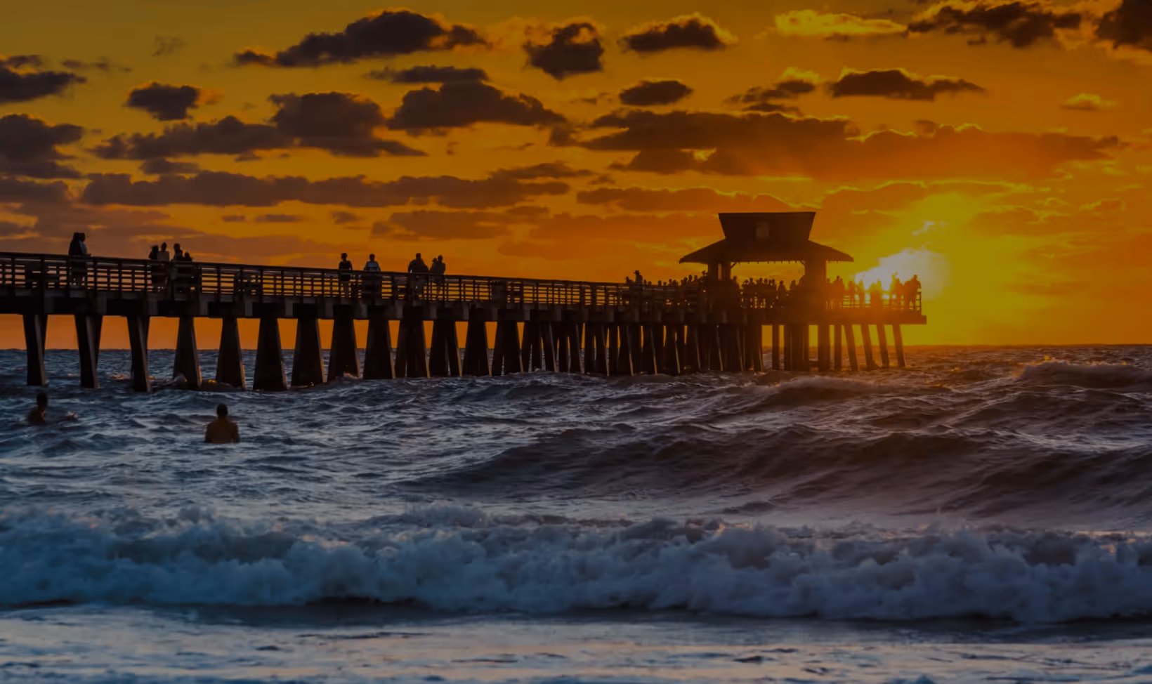 Sunset at Naples Pier in Florida with a crowd of people