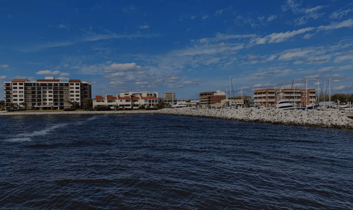 Waterfront view of luxury condos and a stone breakwater in Biddeford, Maine