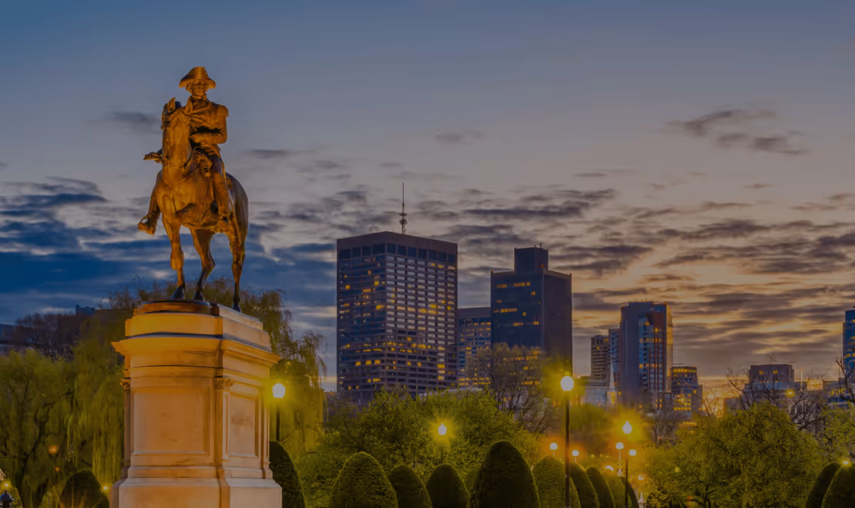 George Washington statue in Boston Public Garden at sunset with city skyline