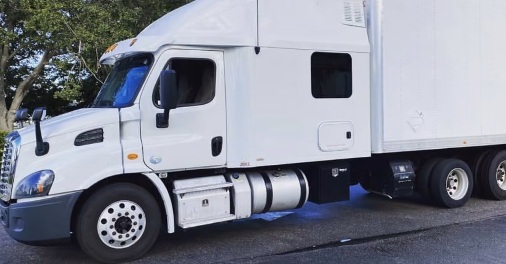 Side view of a white semi-truck trailer parked on asphalt