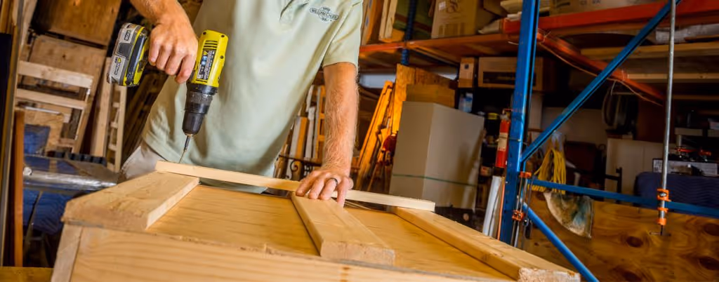Staff member building a small crate - packing and crating services in our climate controlled storage facility | William C. Huff Companies - Moving & Storage