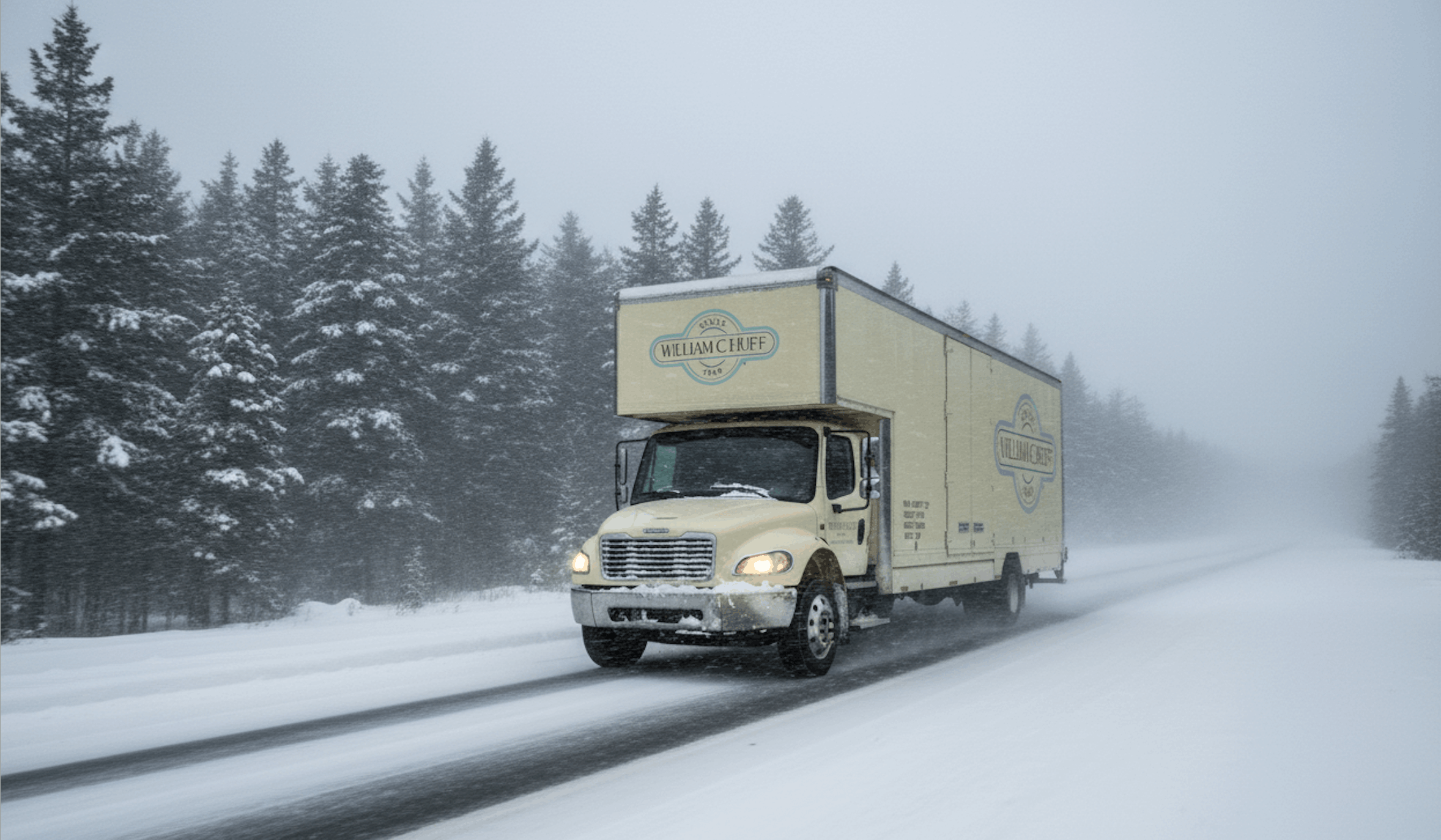 A William C. Huff moving truck parked in a snowy residential neighborhood for winter moving services