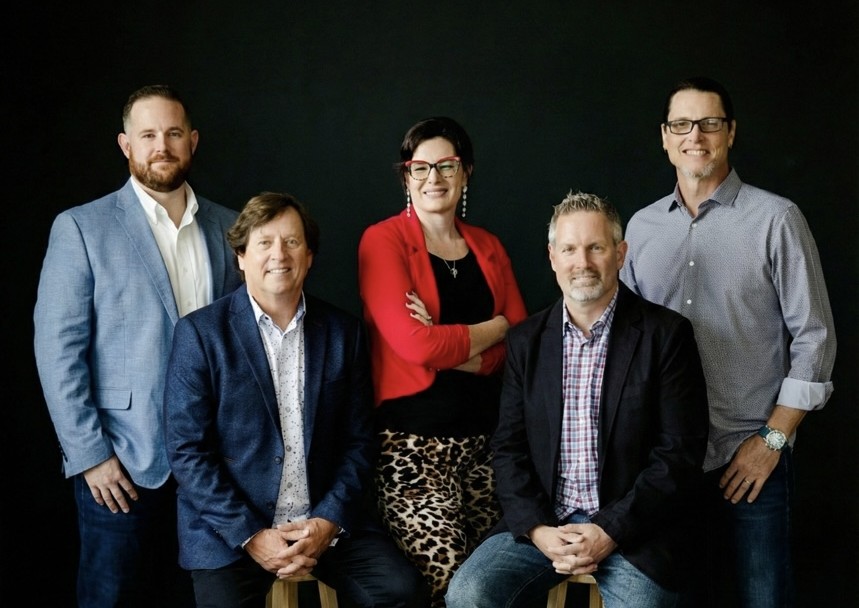 Professional group portrait of the William C. Huff executive team against a black background