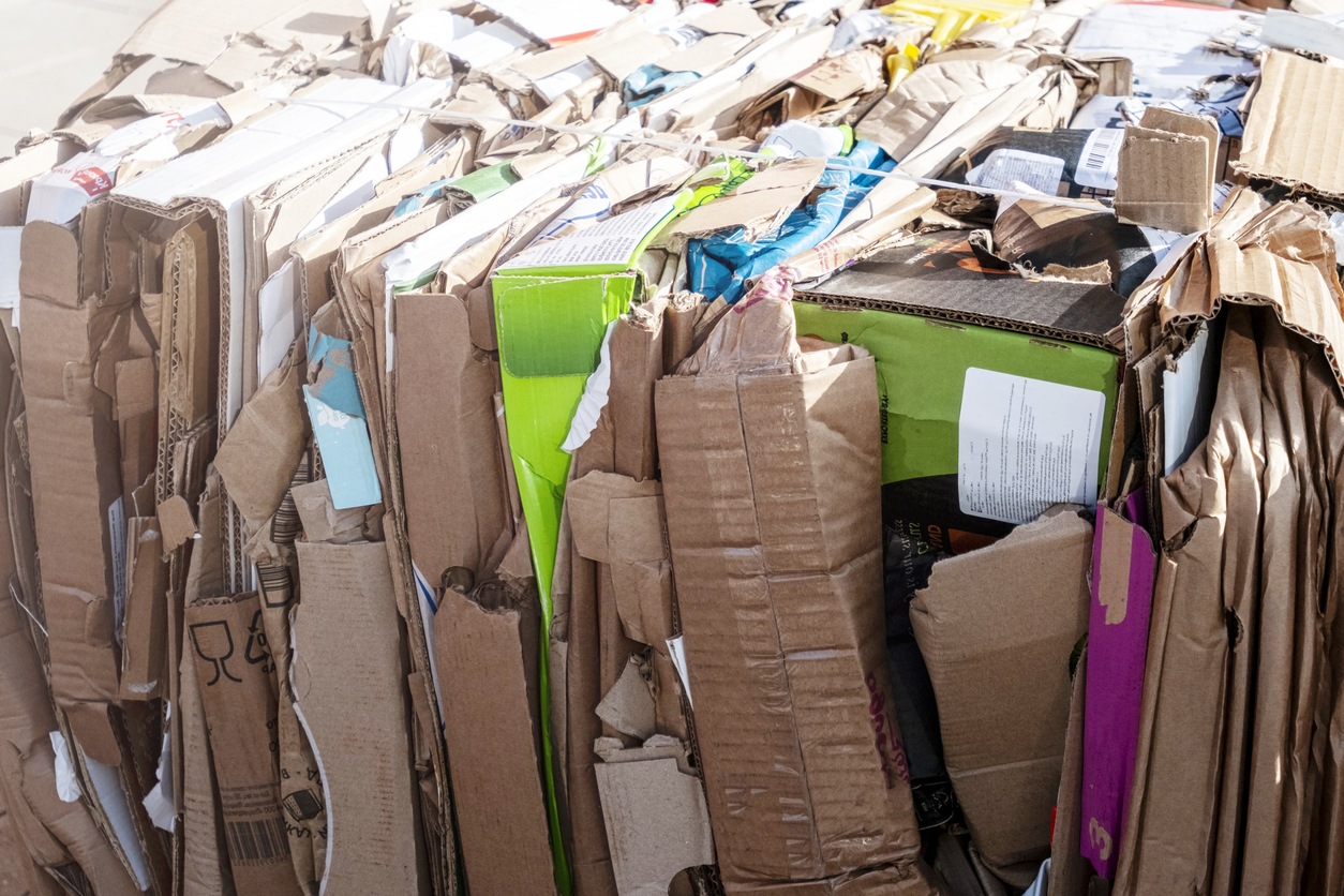 Large bale of recycled cardboard boxes crushed and bundled for eco-friendly moving disposal